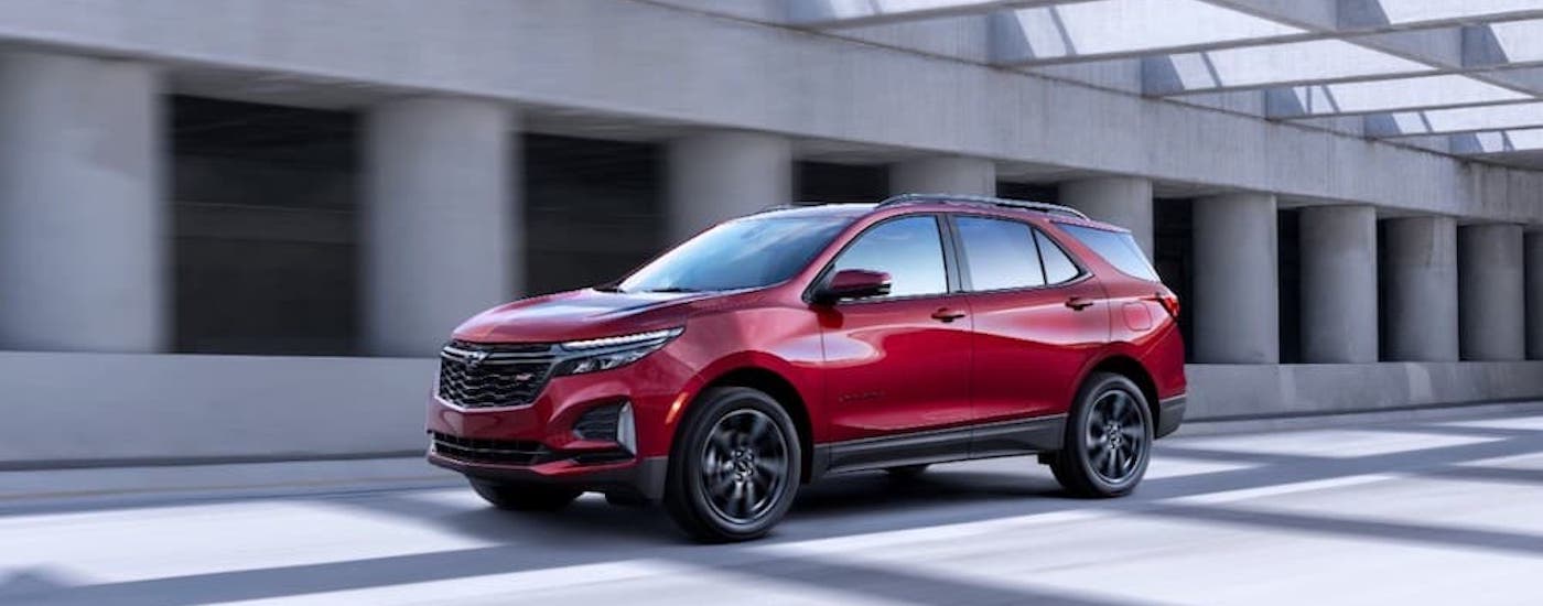 A red 2022 Chevy Equinox RS is shown from the side after leaving a used Chevy dealer.